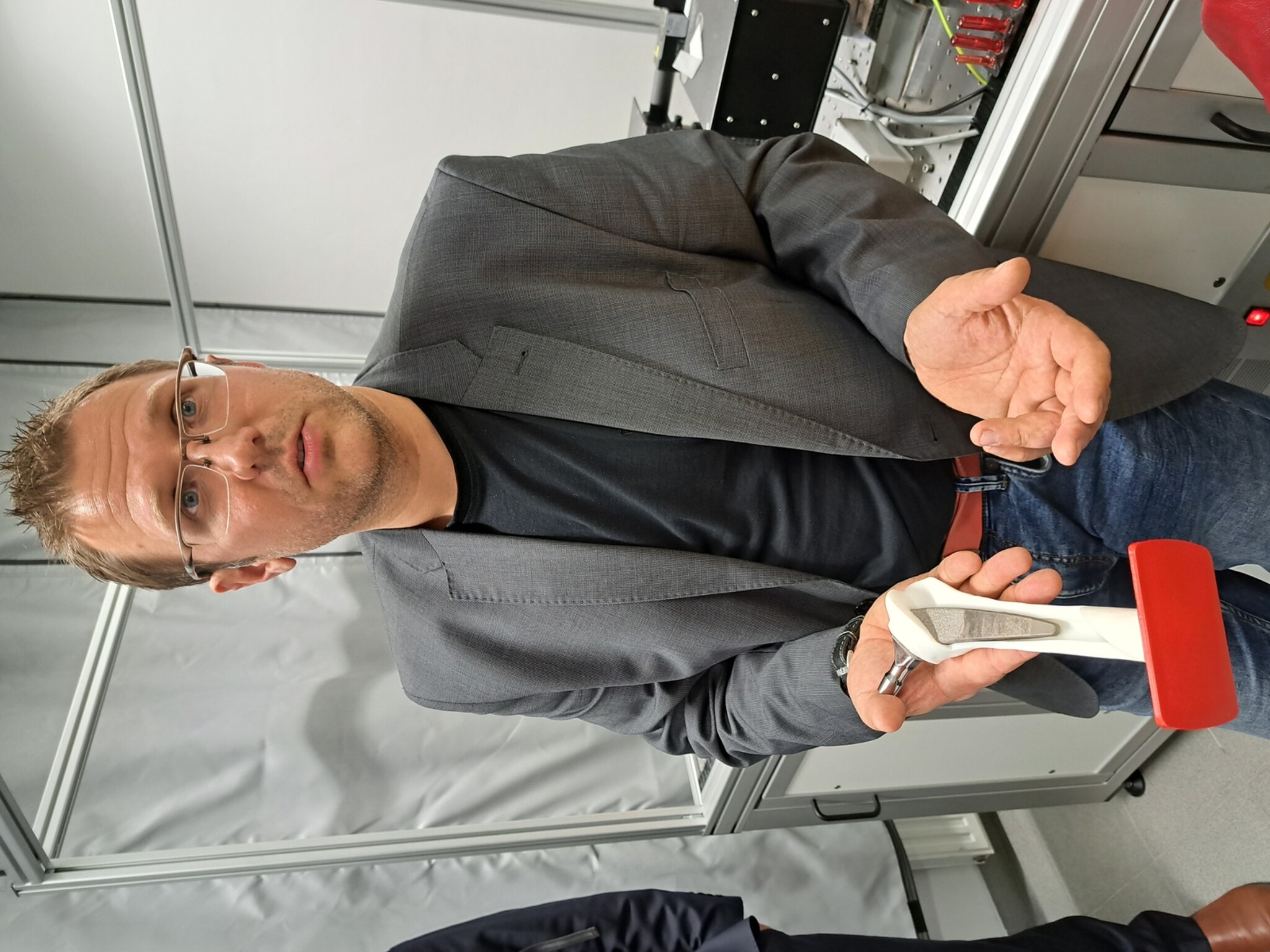 Laszlo Sajti, Head of Nano-Engineering der RHP-Technology GmbH, präsentiert ein mit Silber-Nanopartikel beschichtetetes Hüftimplantaten. 