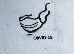 Ein Grafitti mit einer MNS Maske und Covid 19 Schriftzug