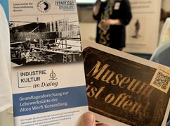 Ein Ausstellungsflyer mit dem Titel Industrie Kultur im Dialog wird vor den...