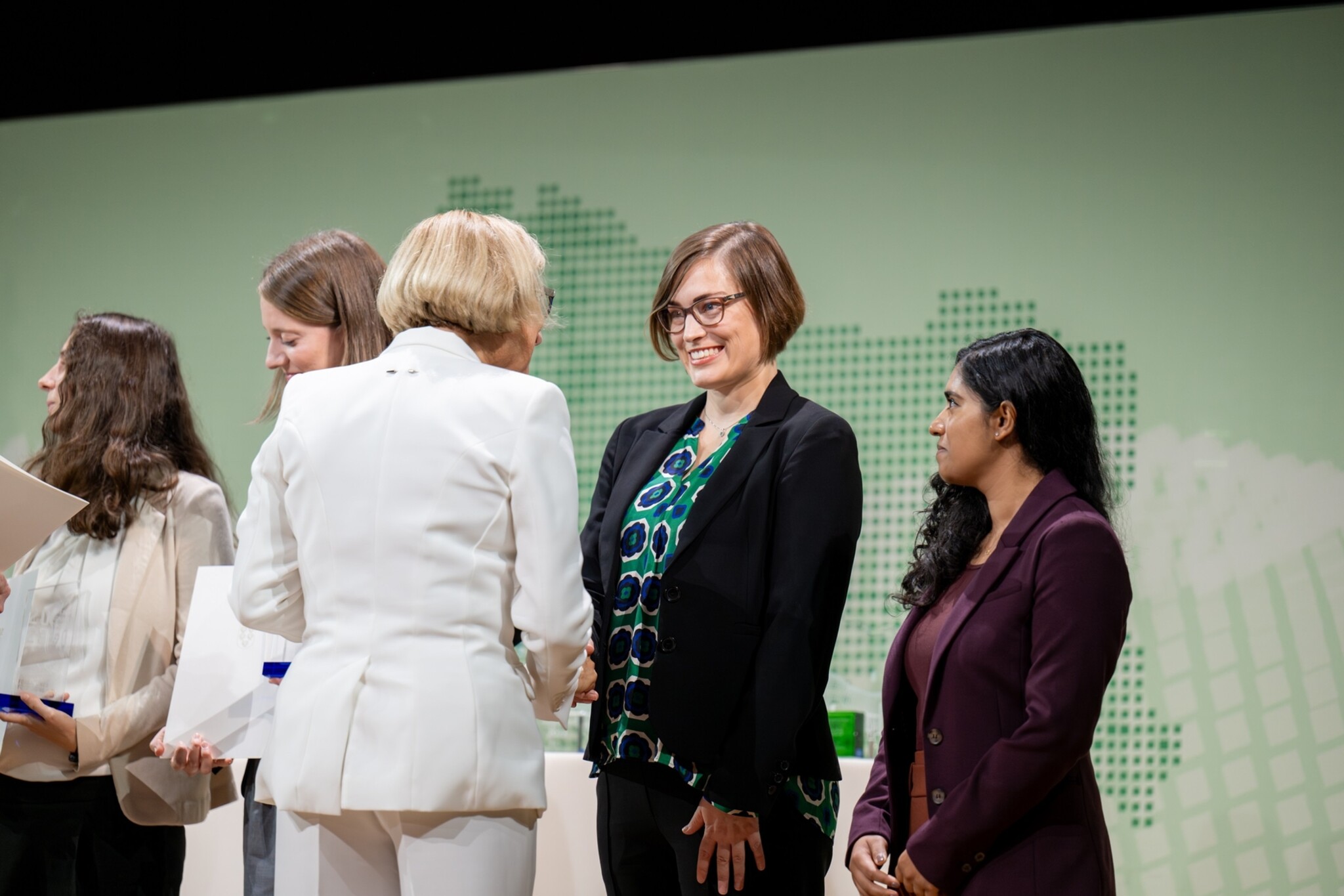 Landeshauptfrau Johanna Mikl-Leitner überreicht den WZP2023 Preis an Agnes Kim auf der Bühne und schüttelt ihre Hand